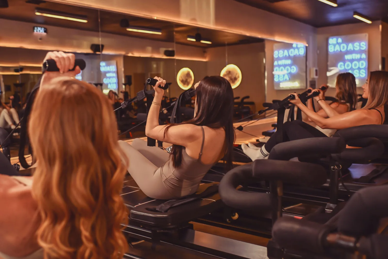 Reformer machines lined up in a bright pilates studio