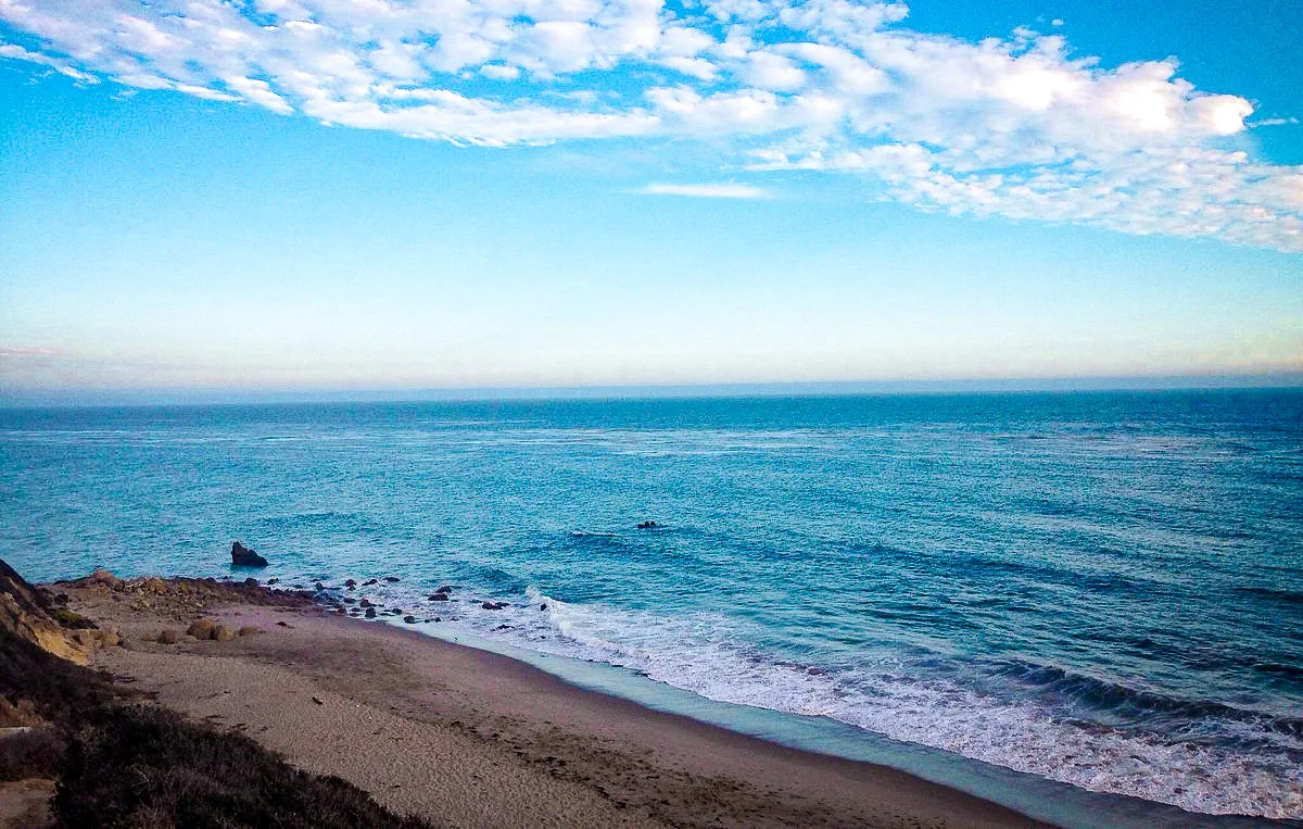 The wide, quiet sand of El Pescador State Beach in Malibu