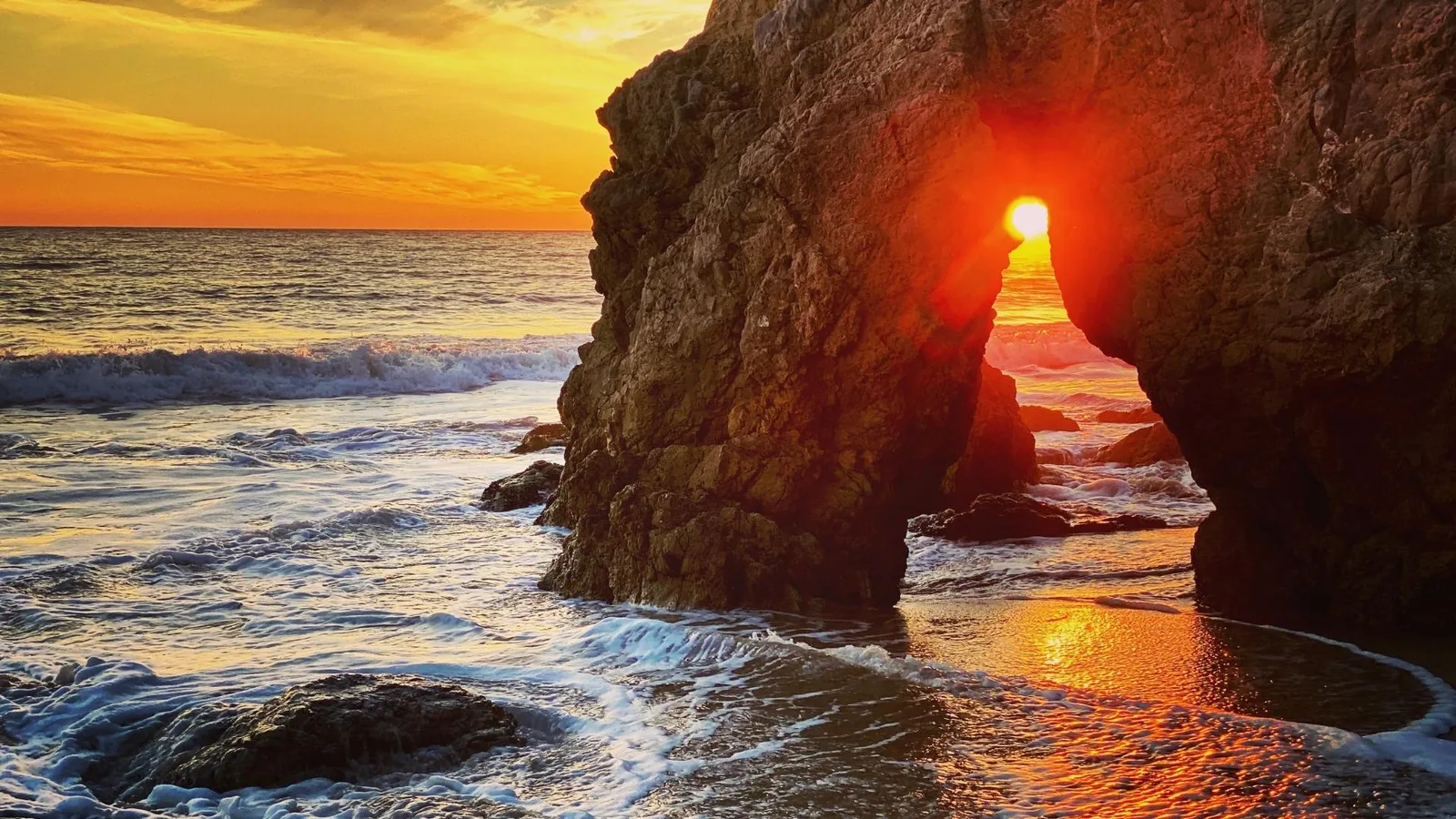 Sunset through the sea arch at El Matador State Beach, Malibu