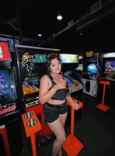 A patron in front of a Space Invaders cabinet at The Paradox Arcade + Bar