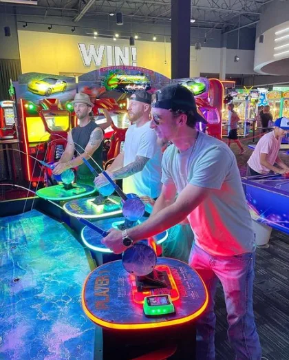 Guys playing an arcade game at Dave and Buster's