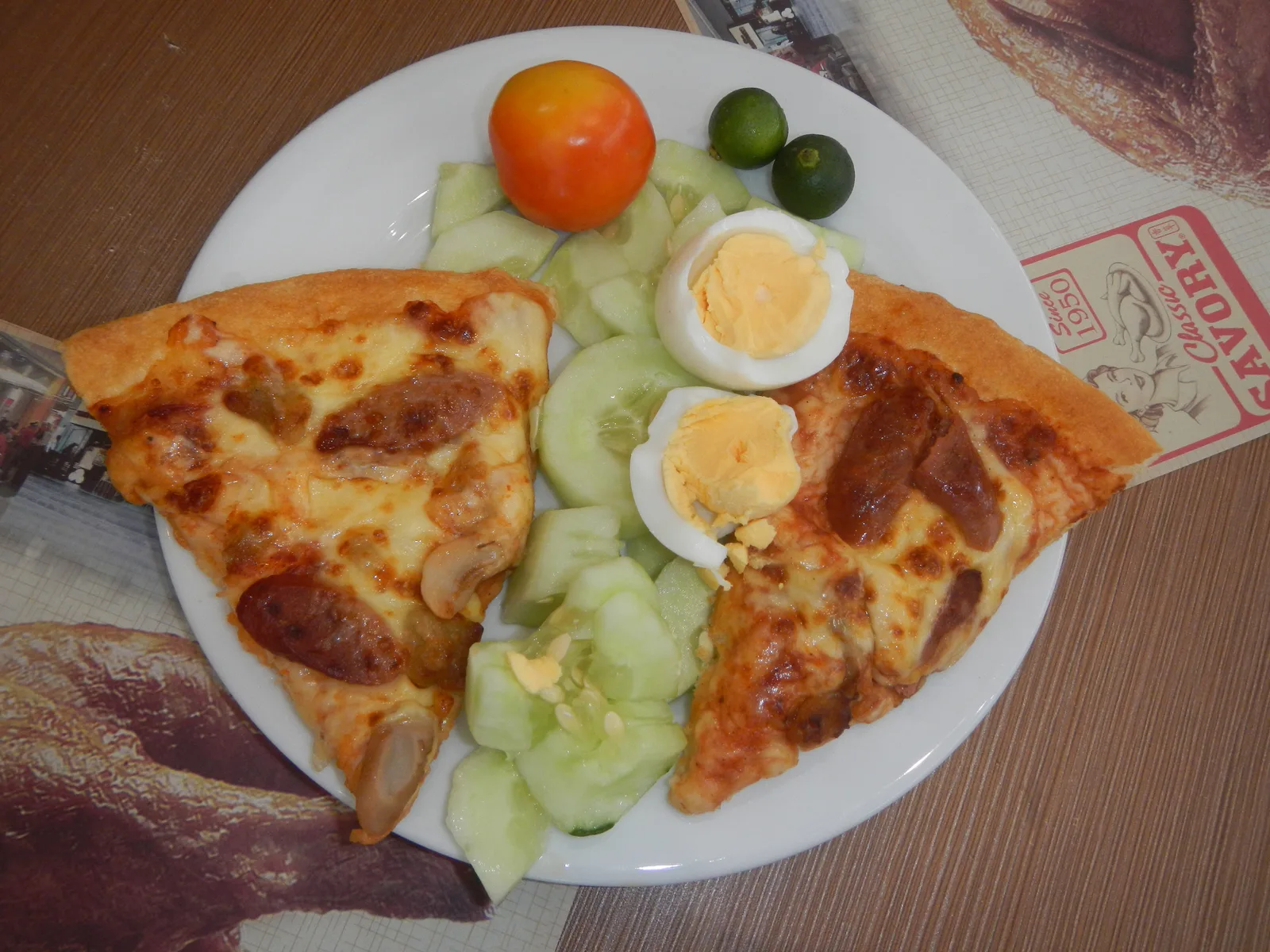Two pizza slices, sliced egg and cucumber on a plate