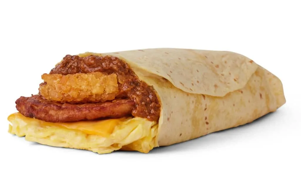 Cut breakfast burrito showing egg, sausage patty and hash brown