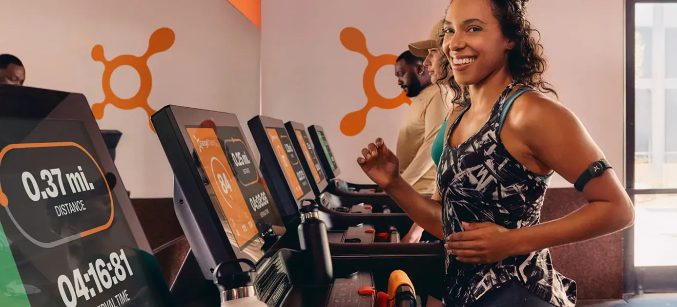 Members on treadmills and rowers in a heart-rate-based Orangetheory class