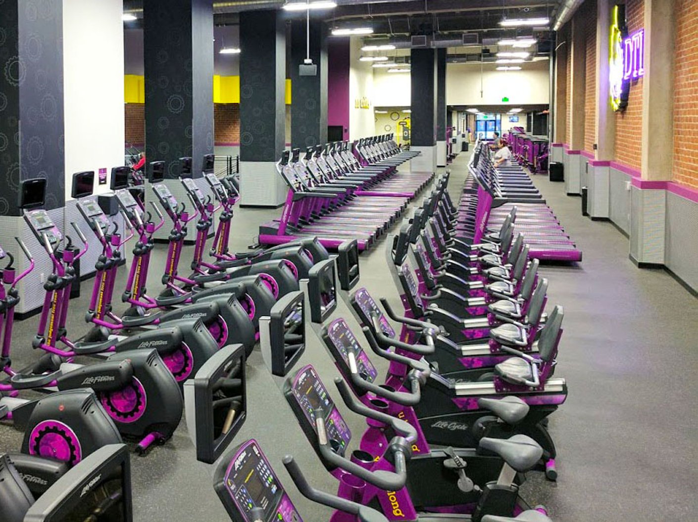 Purple and yellow cardio machines at a Planet Fitness club