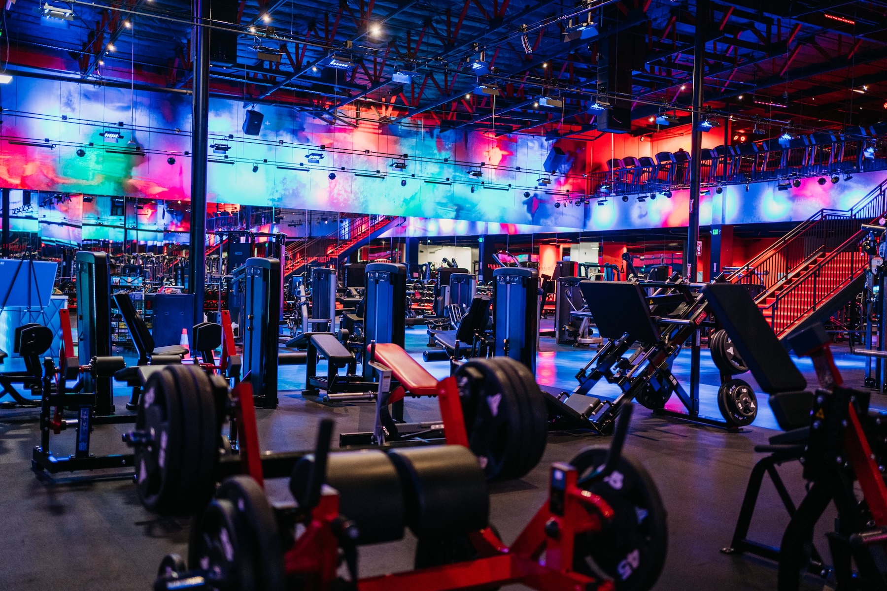 The neon-lit workout floor at Speakeasy Fitness