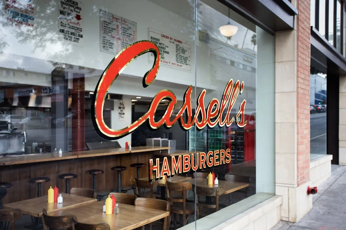 Restaurant window with script signage and booth seating inside