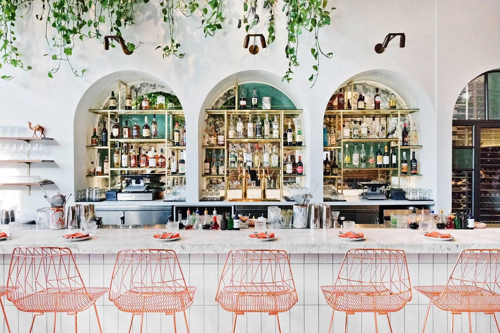 Arched bar with bottle shelves and copper stools