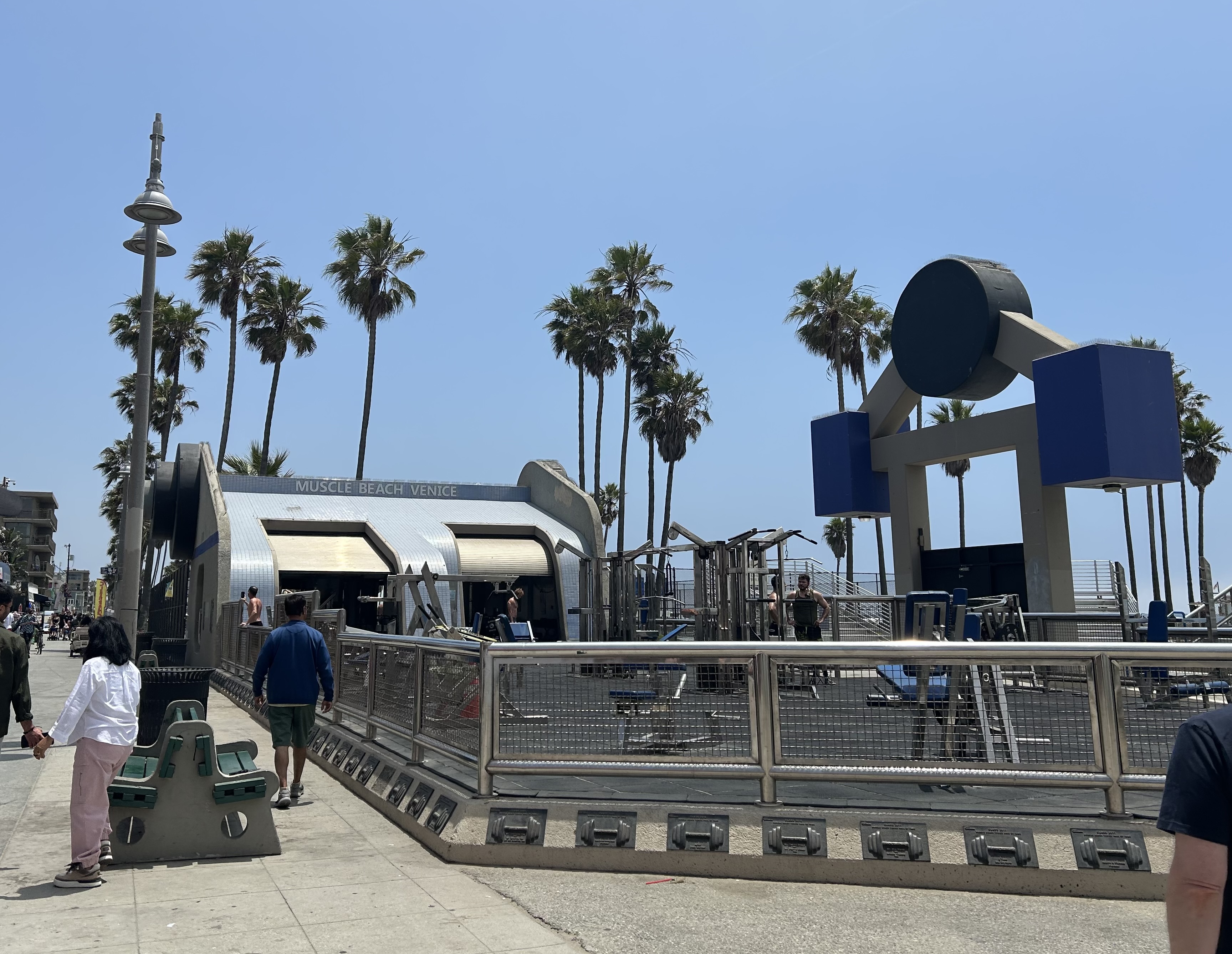 The outdoor Muscle Beach Venice gym on Ocean Front Walk, with its weightlifting platforms and palm-lined boardwalk.