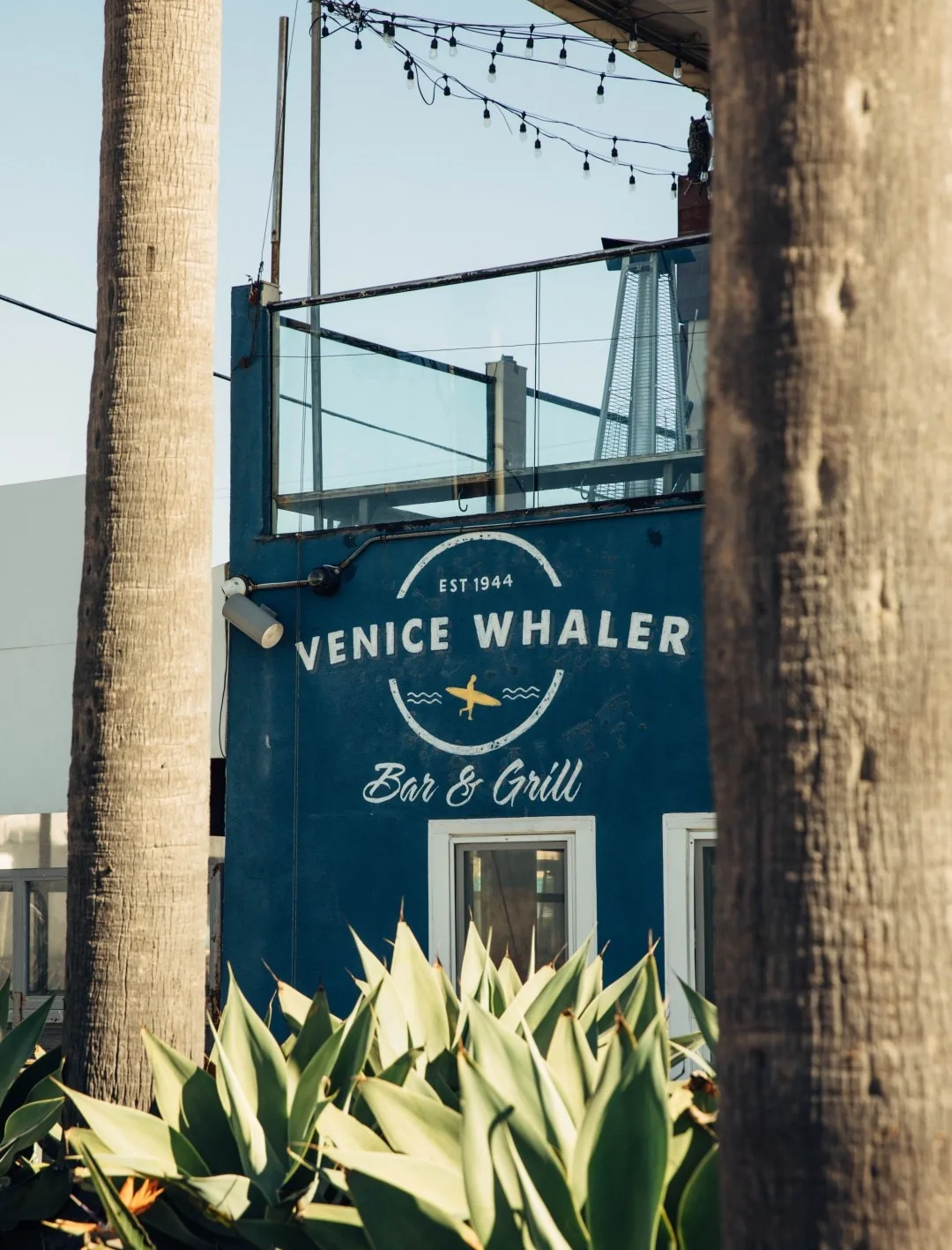 The painted Venice Whaler Bar and Grill sign on a blue wall
