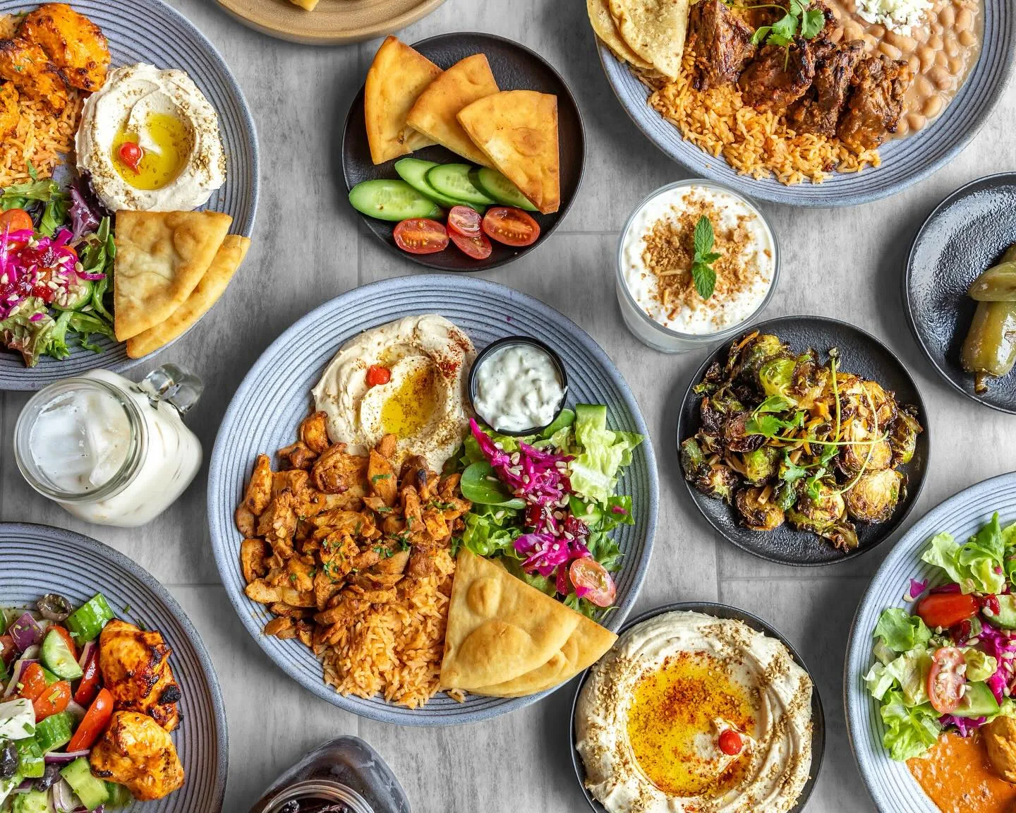 Overhead spread of mezze dishes, salads, pita and dips