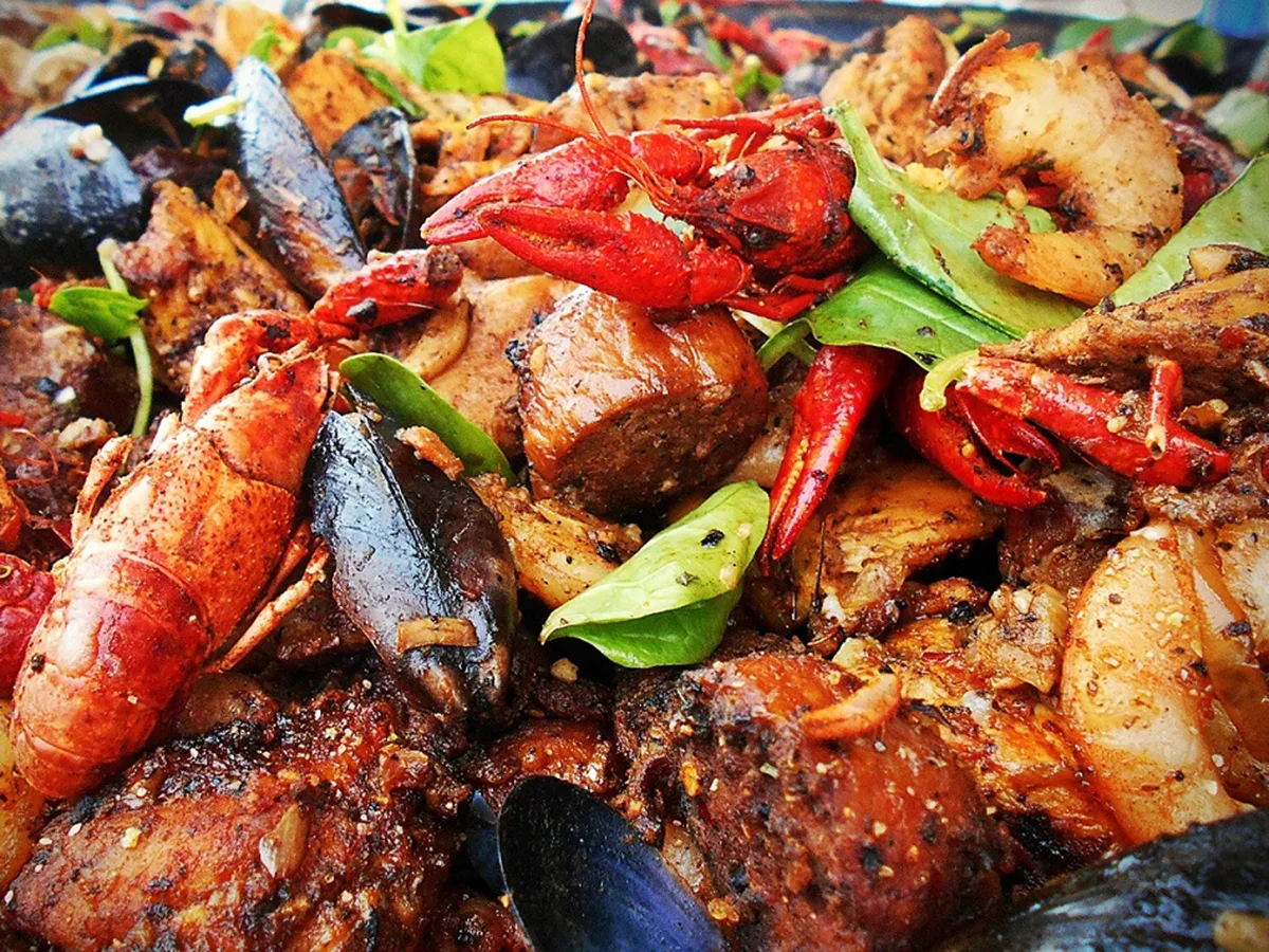 Seafood boil piled with lobster claws, shrimp, mussels and corn
