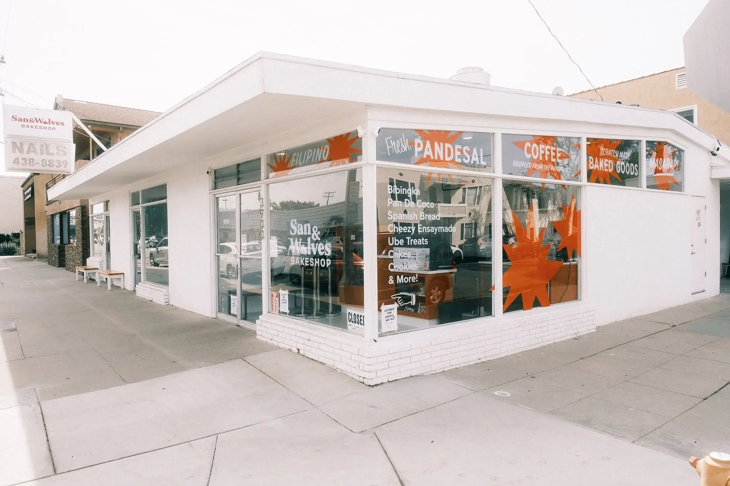 White corner bakery building with signage and large windows