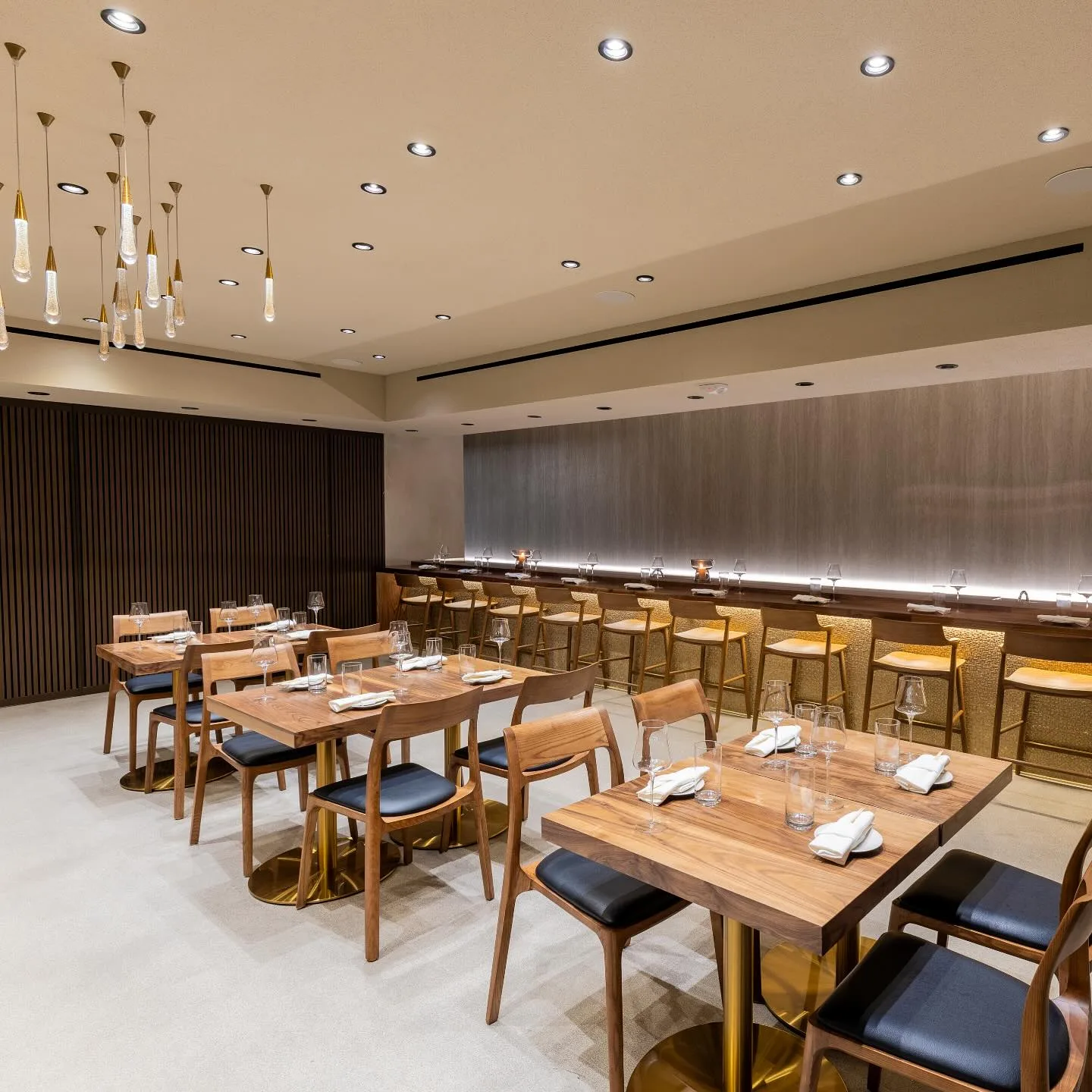 Modern dining room with wood tables and slim pendant lights