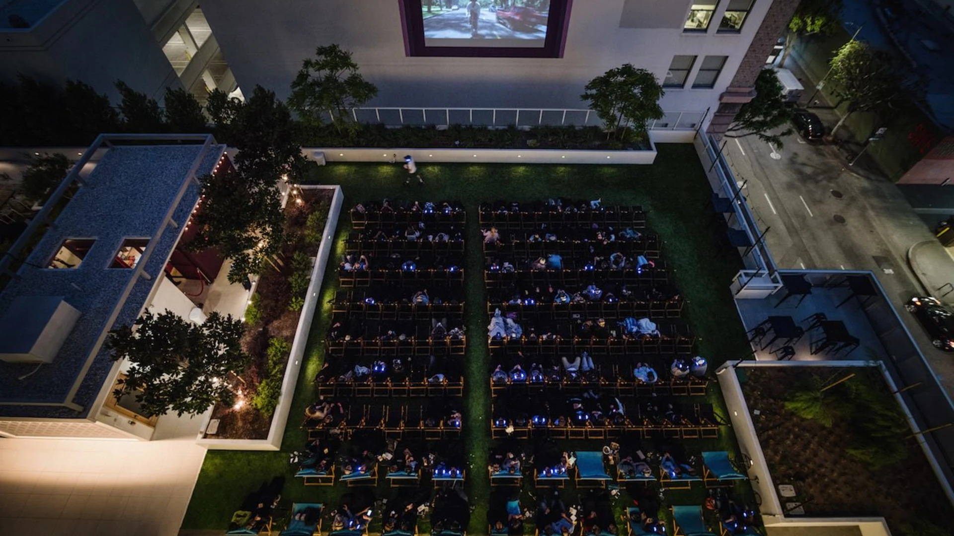 Rooftop Cinema Club's DTLA venue in Downtown Los Angeles, an open-air rooftop cinema with the screen framed against the skyline at night.