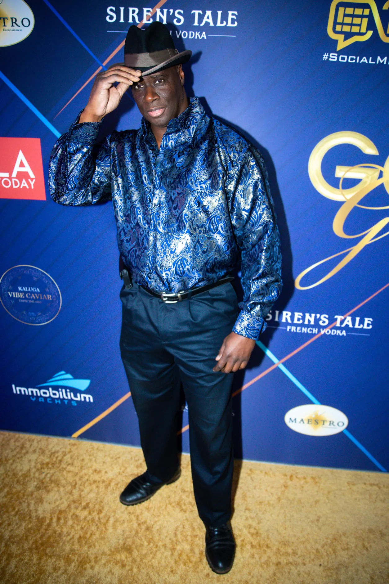 A stylishly dressed celebrity poses on the golden carpet at LA Today's Golden Globes Pre-Party in West Hollywood, CA on January 4th, 2025.