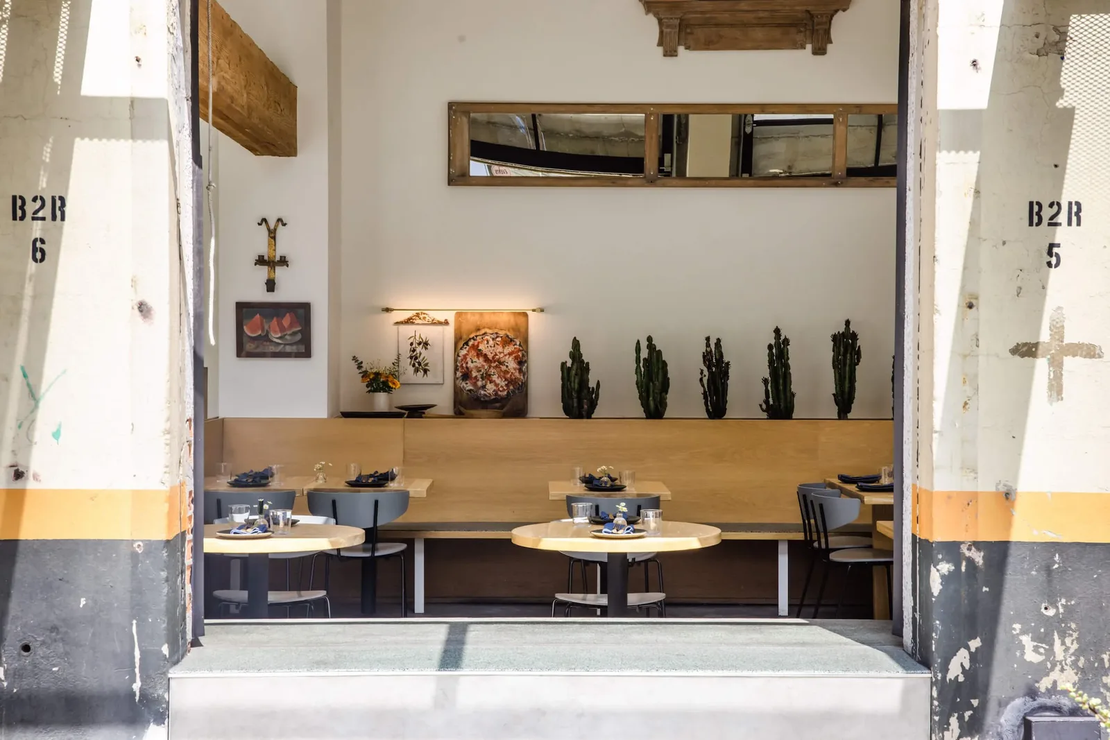 Minimal dining room with small round tables and shelf sculptures