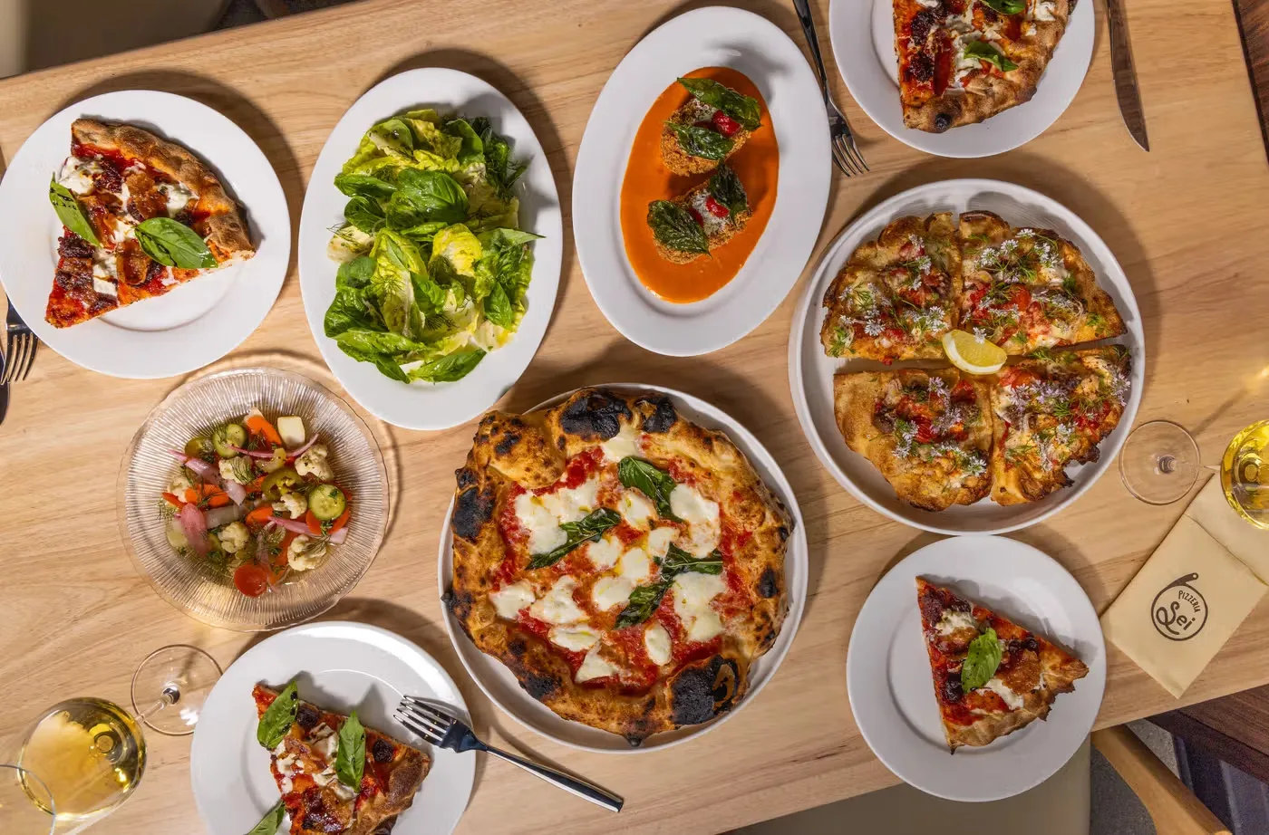 Overhead view of three topped pizzas on plates