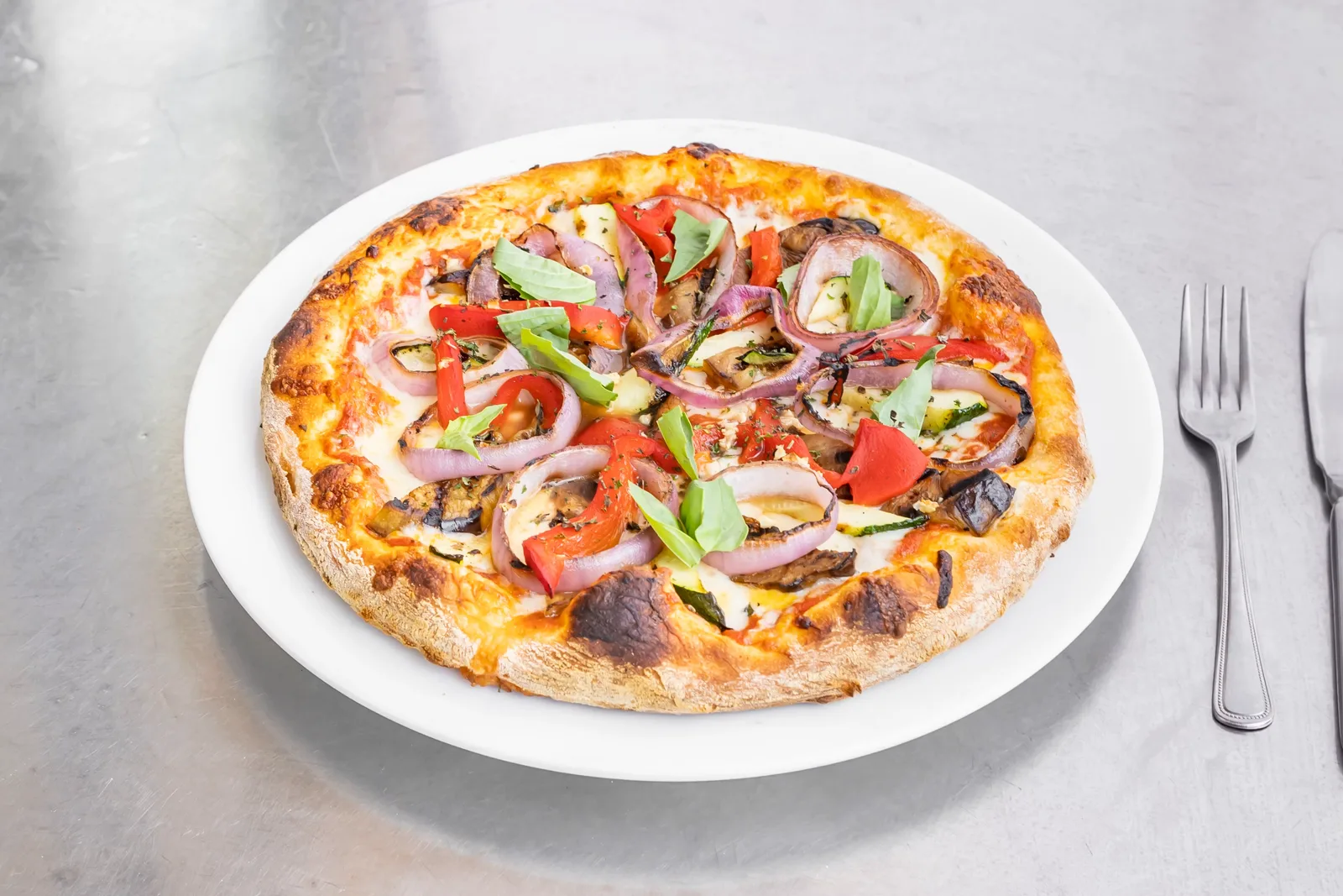 Pizza served on an oval plate beside a fork