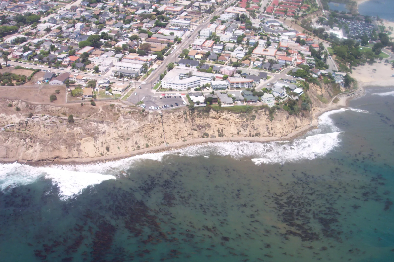 The crumbling concrete ruins of San Pedro's Sunken City seen from the fenced overlook above the Pacific