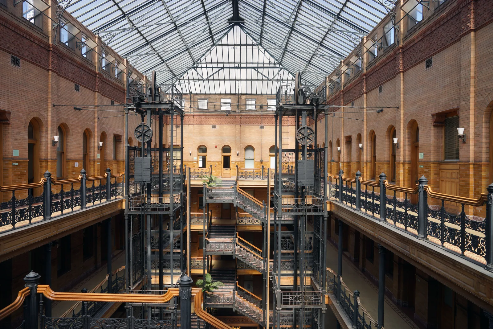 The sunlit Victorian atrium of the Bradbury Building with its wrought-iron staircases, open elevators and glass skylight
