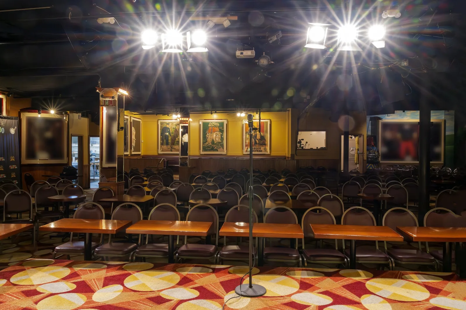 Empty club showroom with stage lights, wooden chairs and patterned carpet