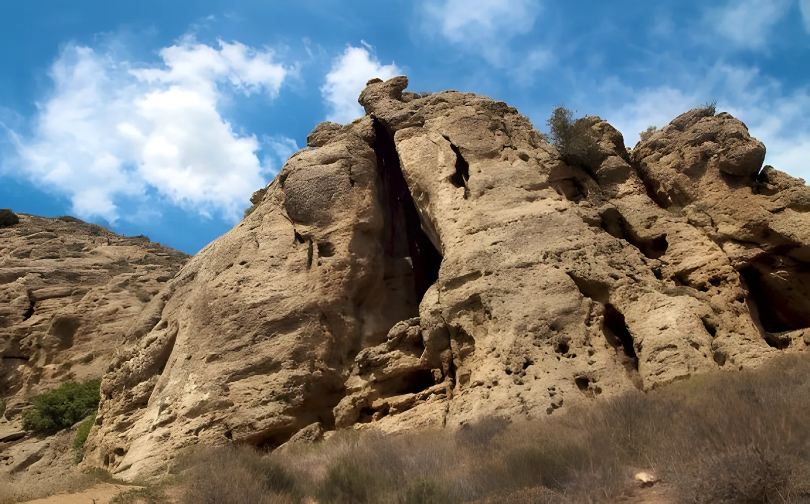 Weathered sandstone rock formation under a bright blue sky