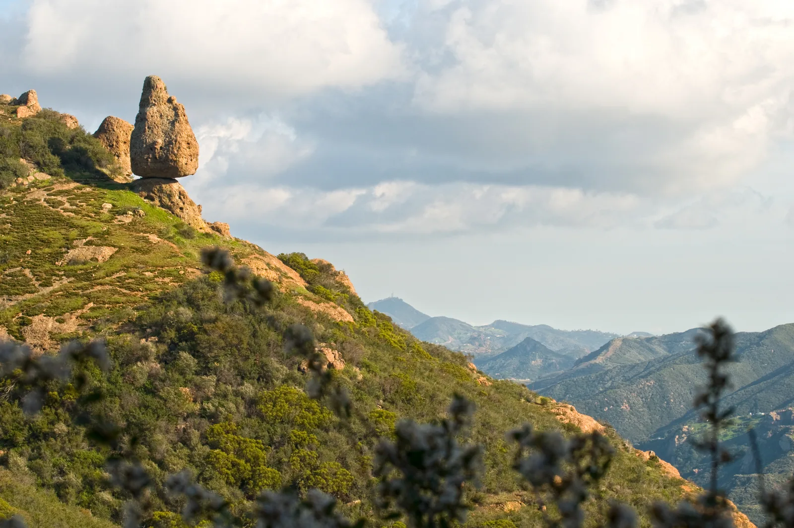 Rocky outcrop on a ridge with mountain ranges beyond