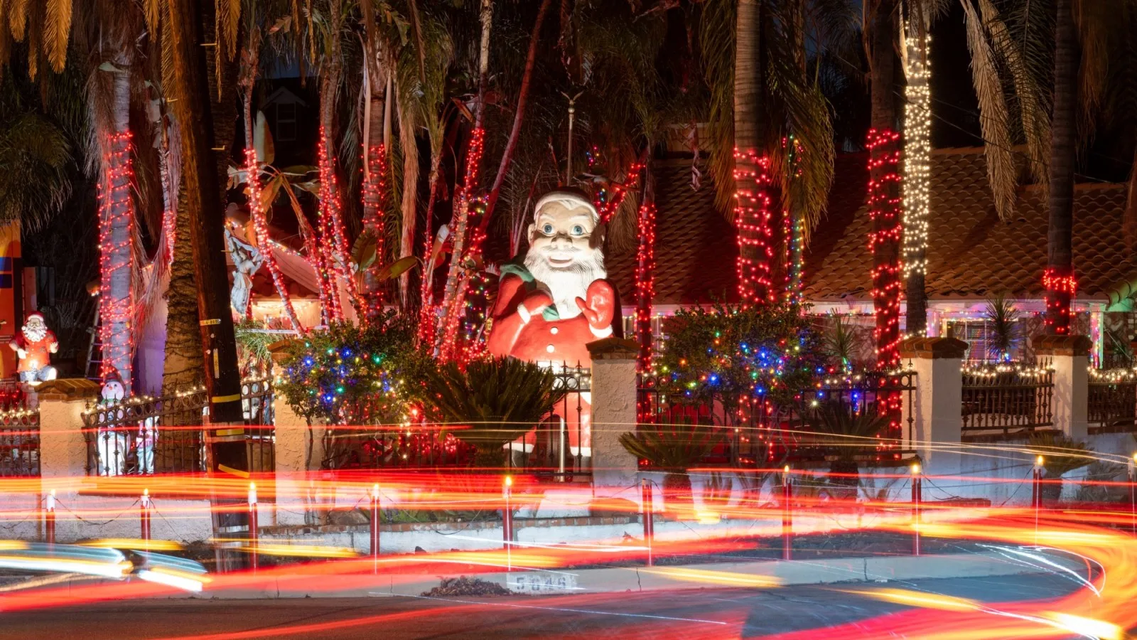 A front yard packed with Christmas lights and a lit Santa
