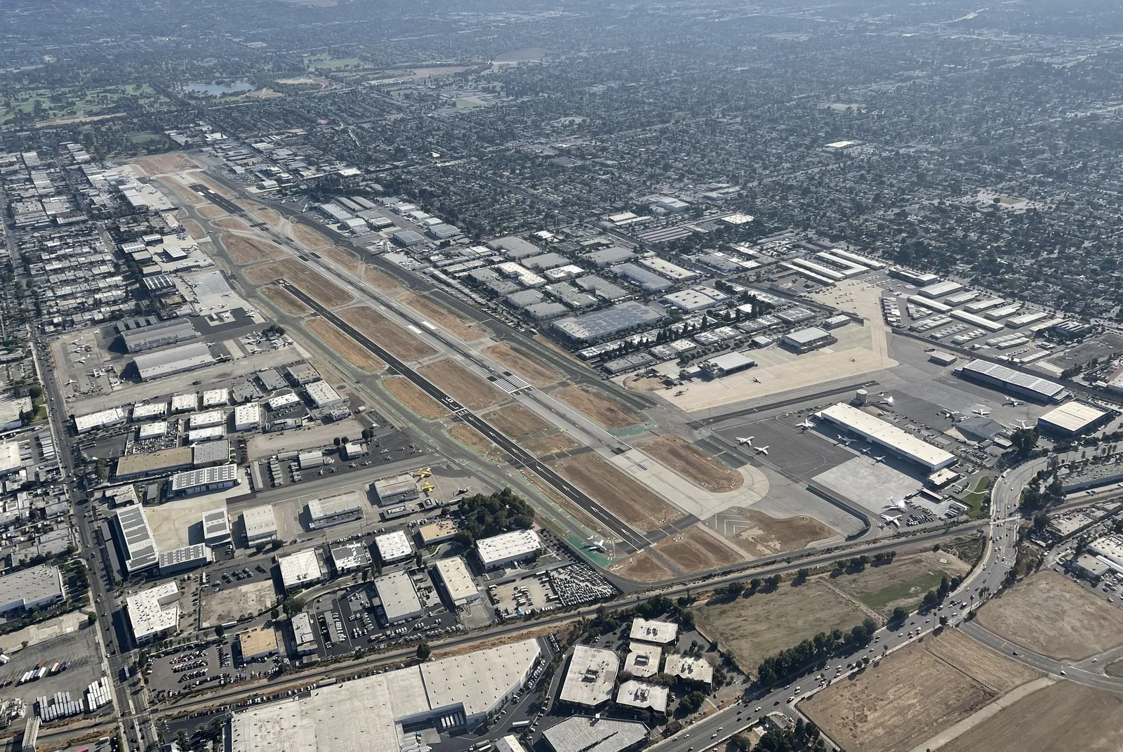 Aerial view of airport runways, hangars and surrounding industrial blocks