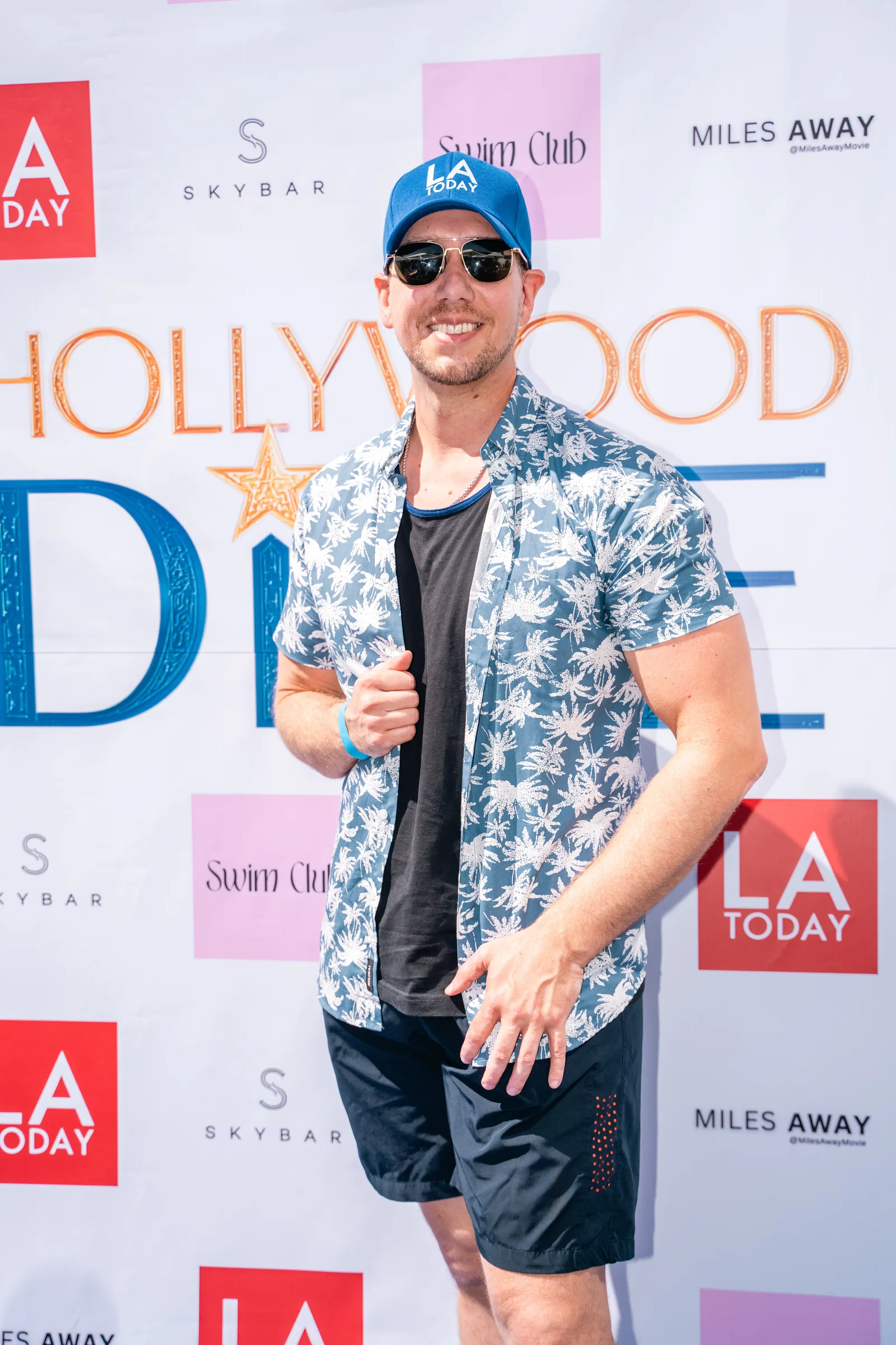 Guest in an open palm print shirt at the branded photo wall