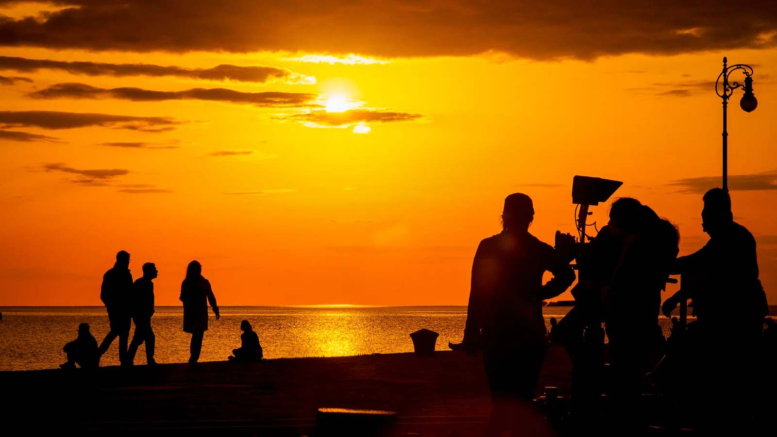 Filming on location at the Santa Monica beach in California at sunset