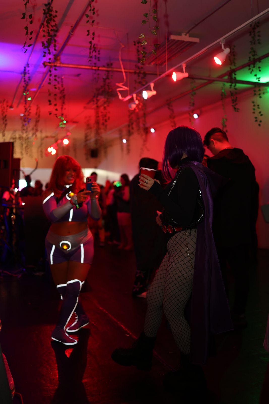 A costumed guest poses on the dance floor as the crowd moves around