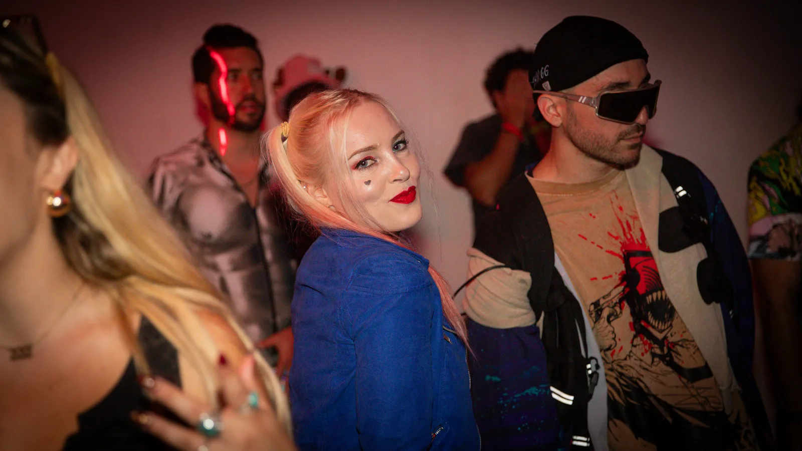 Three guests in costume look back at the camera on the dance floor