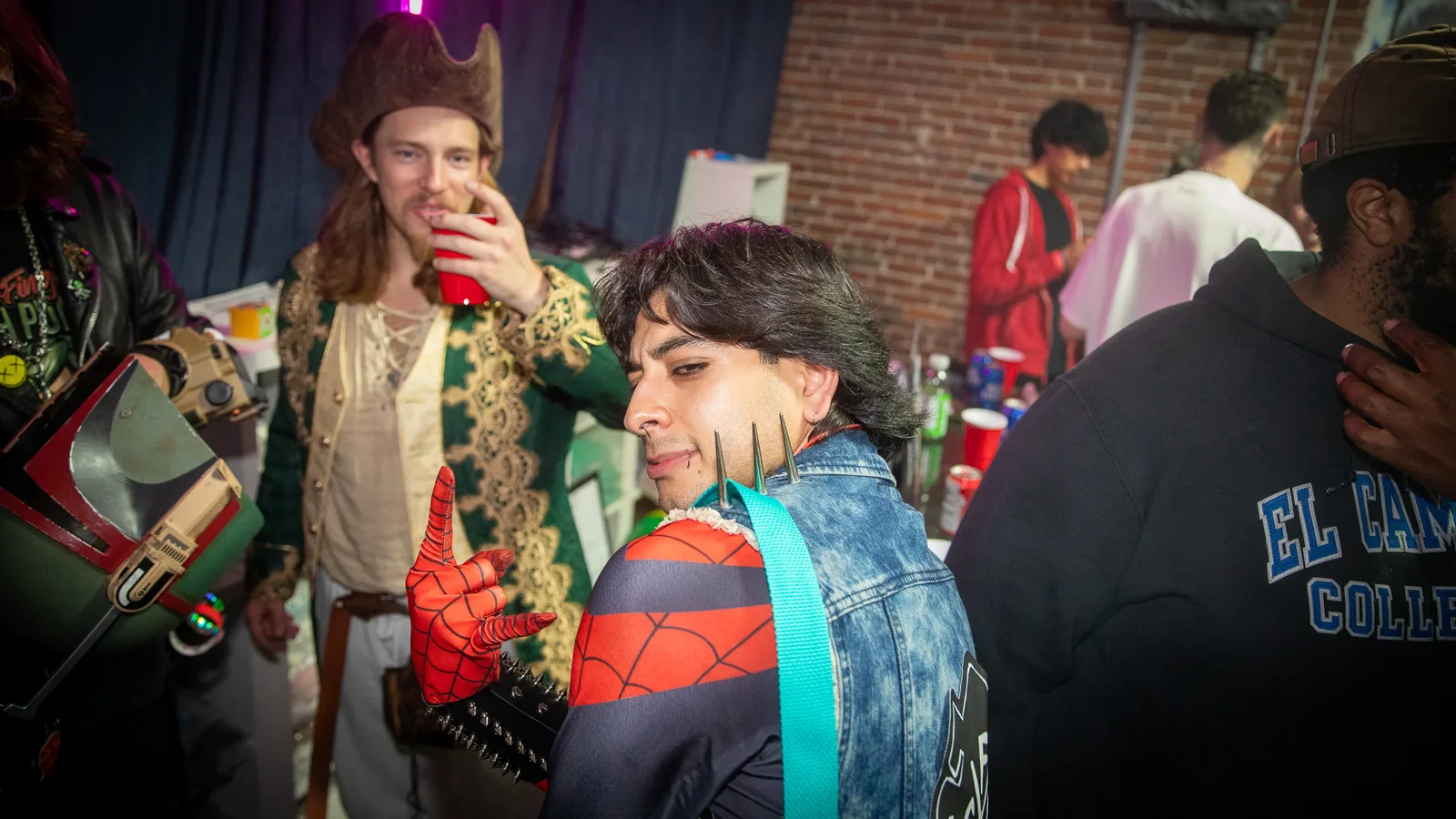 Two guests in pirate and comic costumes drink near the bar