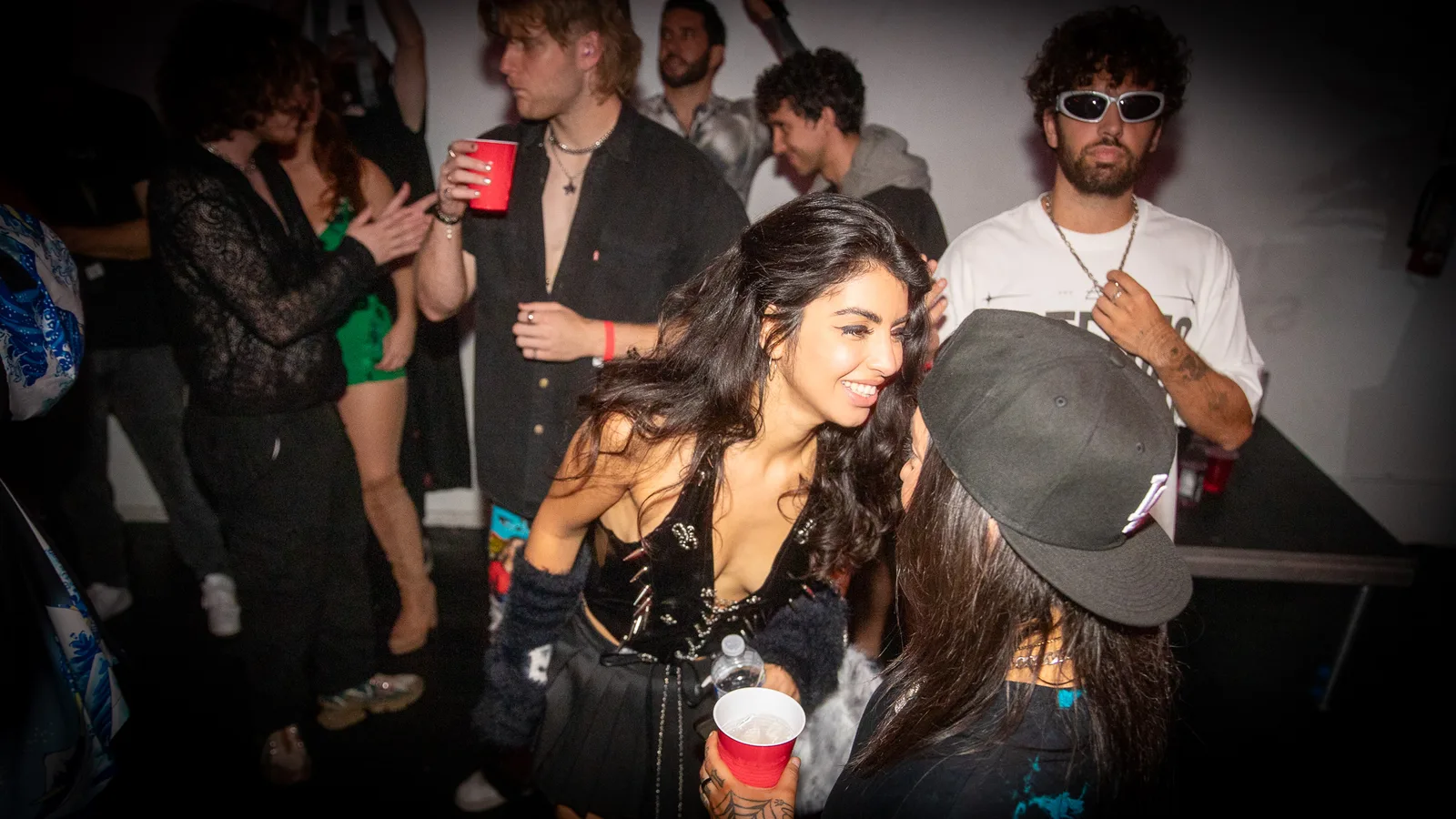 A guest dances with a red cup in a packed crowd