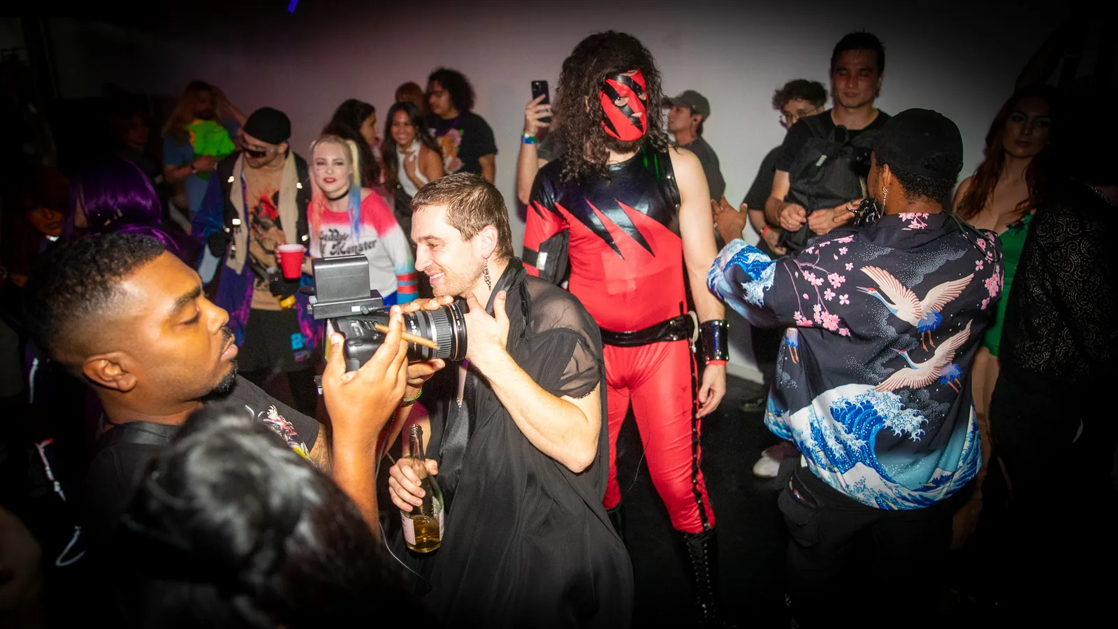 A photographer shoots a costumed guest as the crowd watches