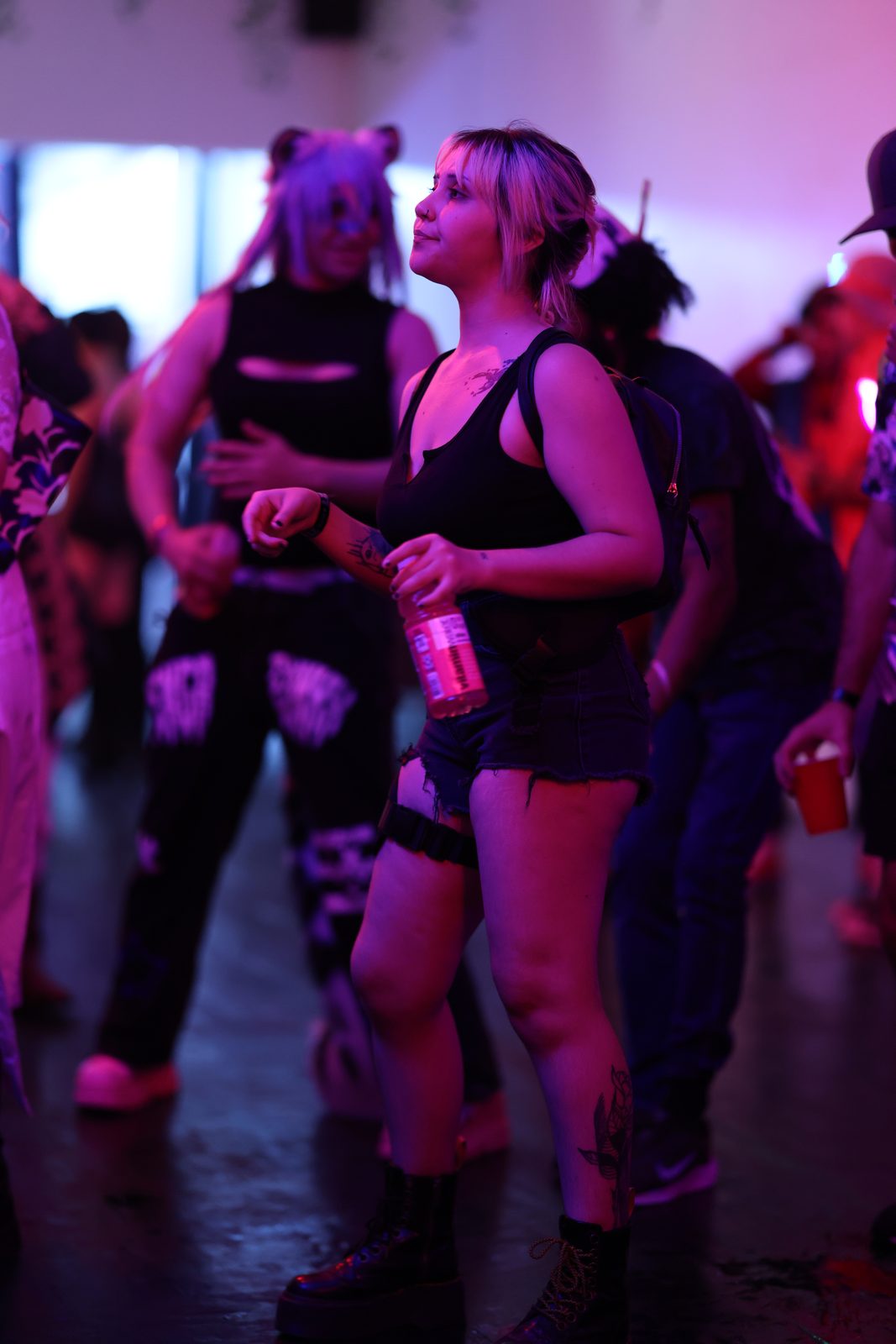 Guests in costume dance and drink in a bright warehouse room