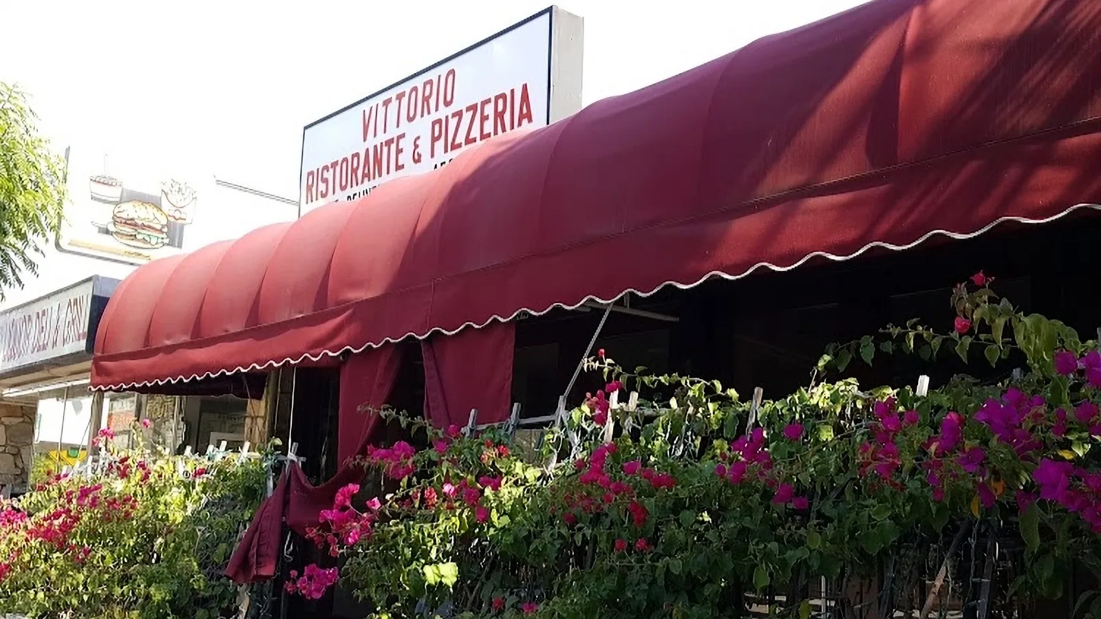 Vittorio's Restaurant in Pacific Palisades with flowers outside and a red awning