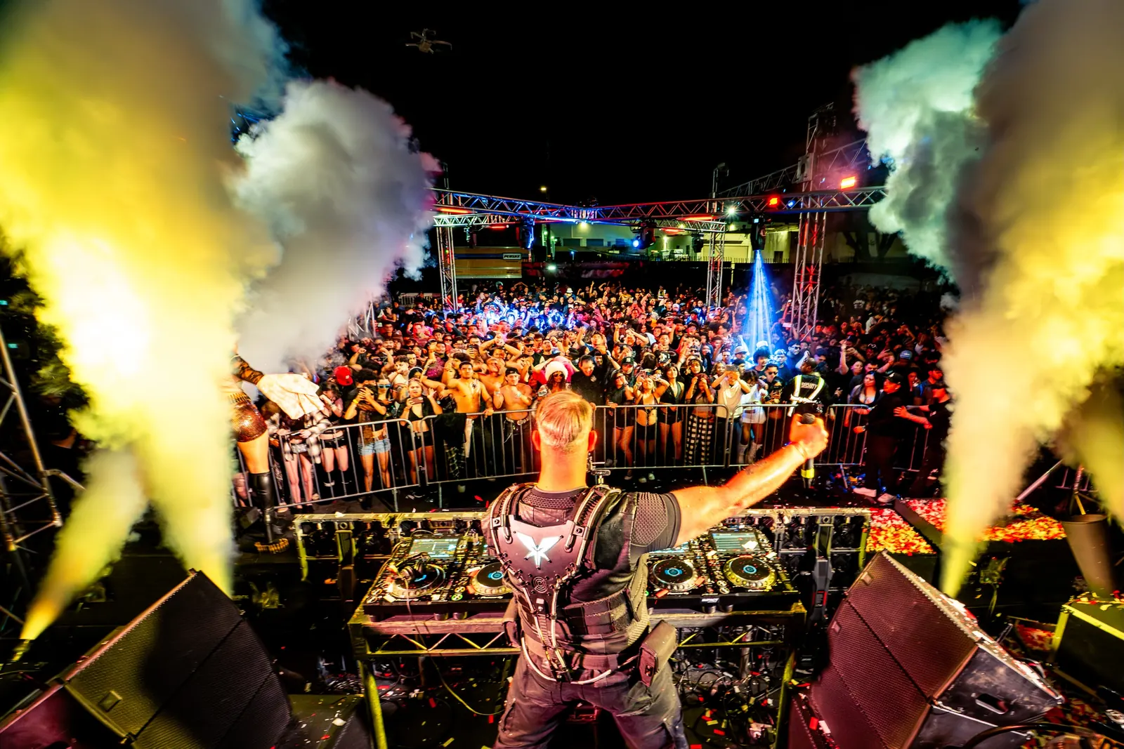 A crowded late-night party with the DJ under CO2 jets