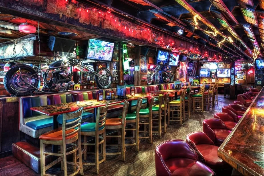The neon-lit bar room and booths at Barney's Beanery