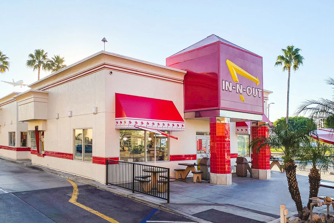 An In-N-Out Burger storefront with palm trees behind it