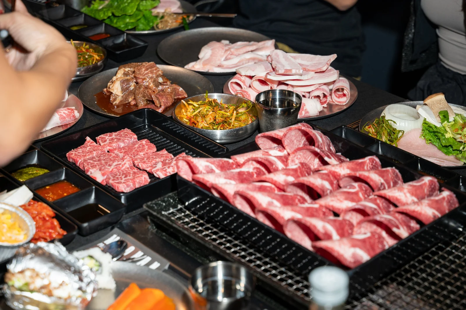 Raw cuts laid out over the tabletop grill at MOOHAN Korean BBQ