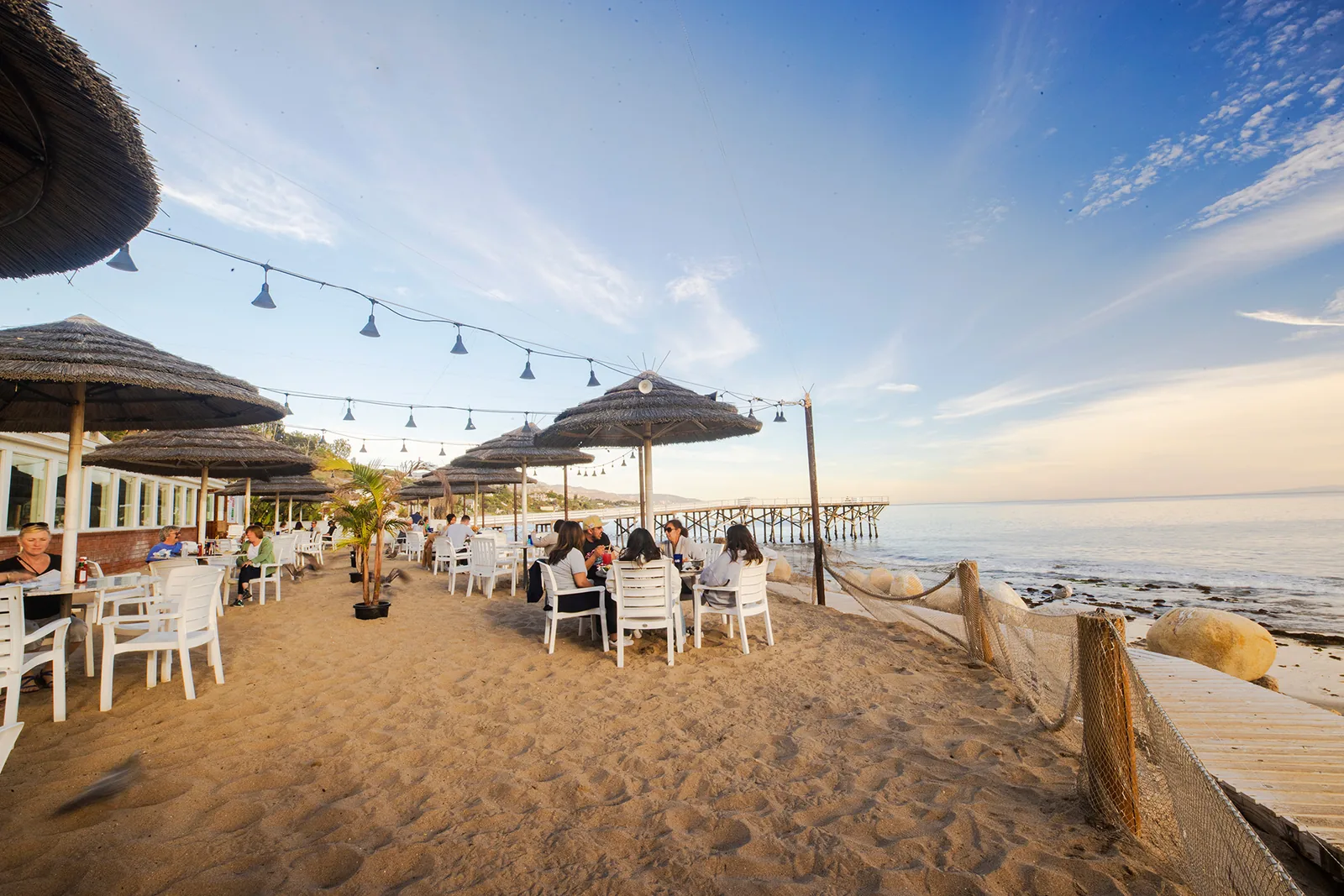 Umbrella tables set out on the sand at Paradise Cove Beach Cafe, Malibu