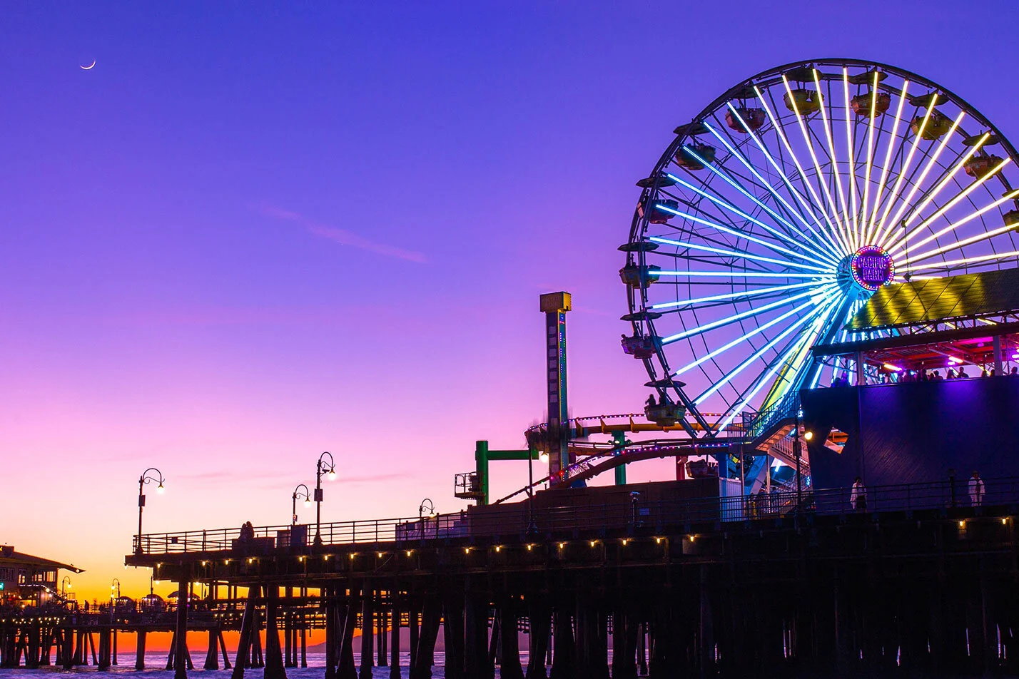 The Ferris wheel and roller coaster on the Santa Monica Pier at dusk