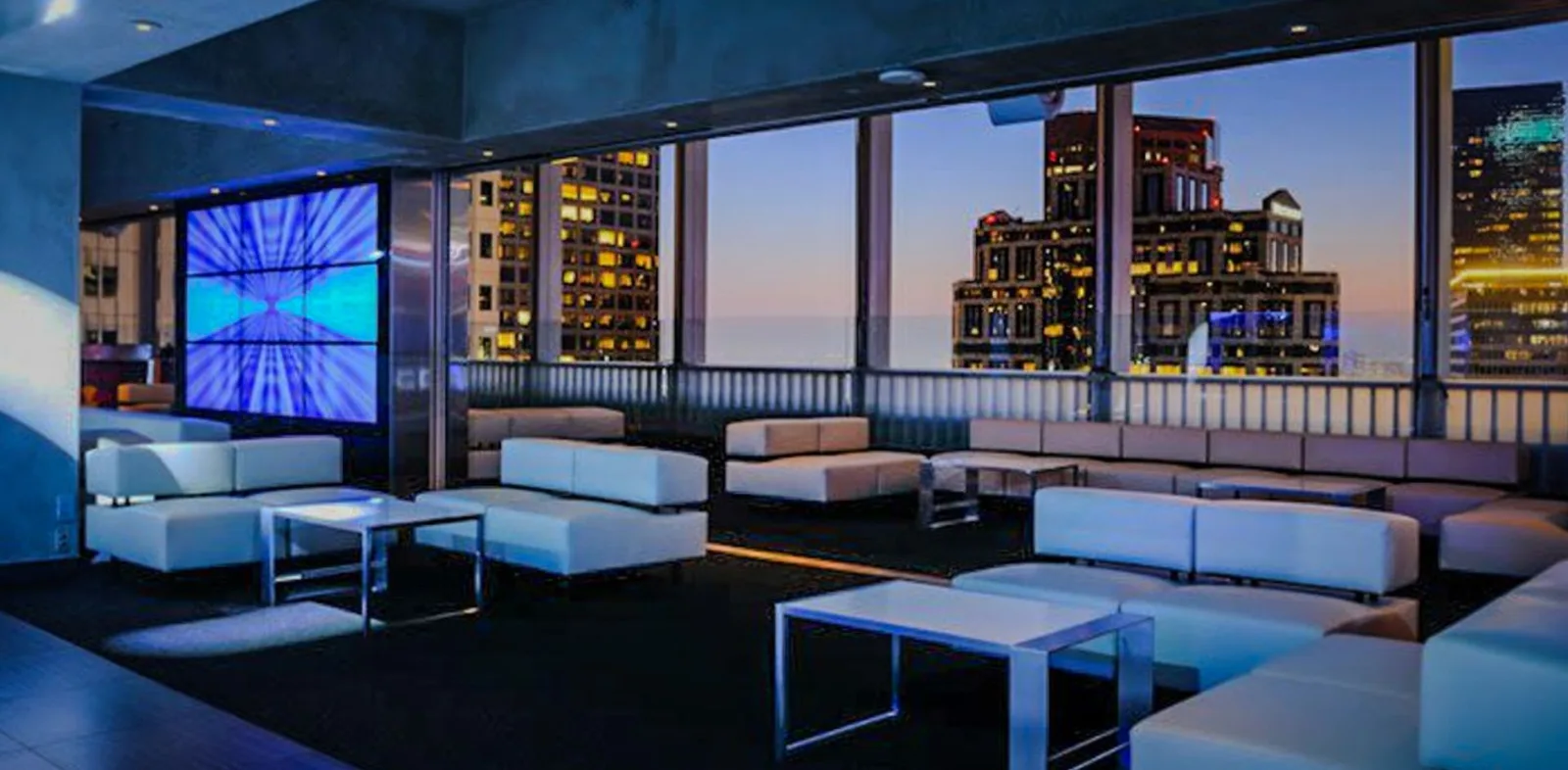 Elevate Lounge rooftop in Los Angeles with a fading sunset in the background DTLA skyline