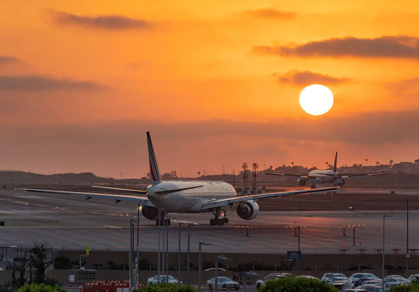 Airliners parked at Los Angeles International Airport gates at sunset
