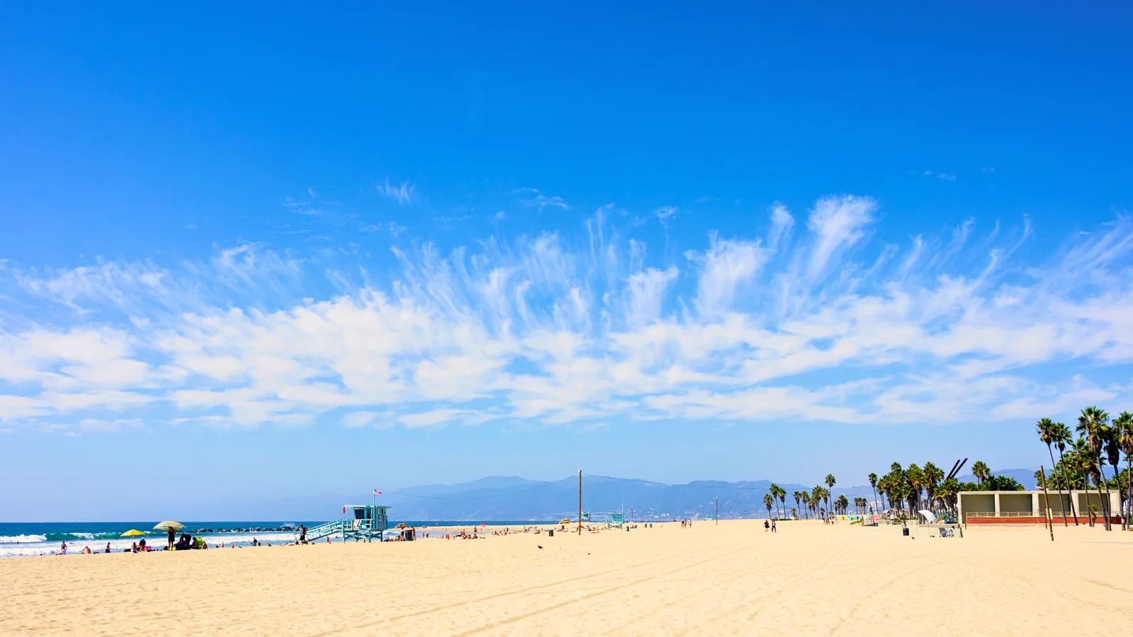 Bright blue sky with white clouds over a sunny, sandy Los Angeles beach