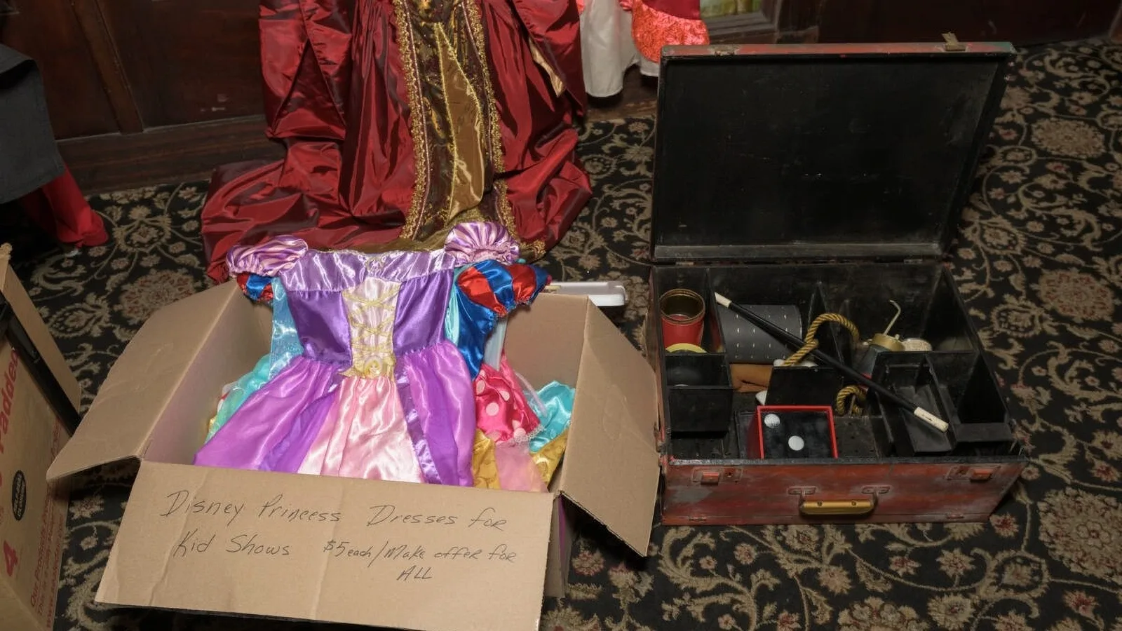 Flea market table with kids' princess dresses in a box and antique irons