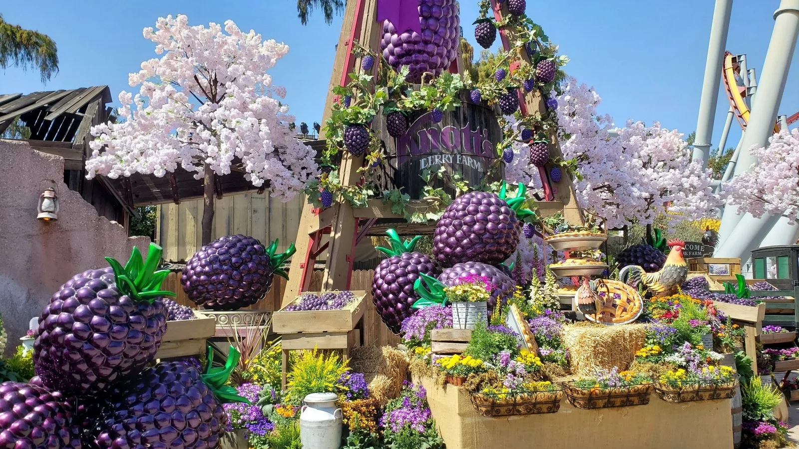 Parade float decorated with giant purple berries and pale blossom trees